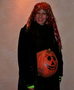 I wish I had a pic of her in her sassy Spider Woman dress.  Alas, I don't.  But this was her clever concoction the year she was pregnant with her daughter.  The pumpkin IS her belly--painted.